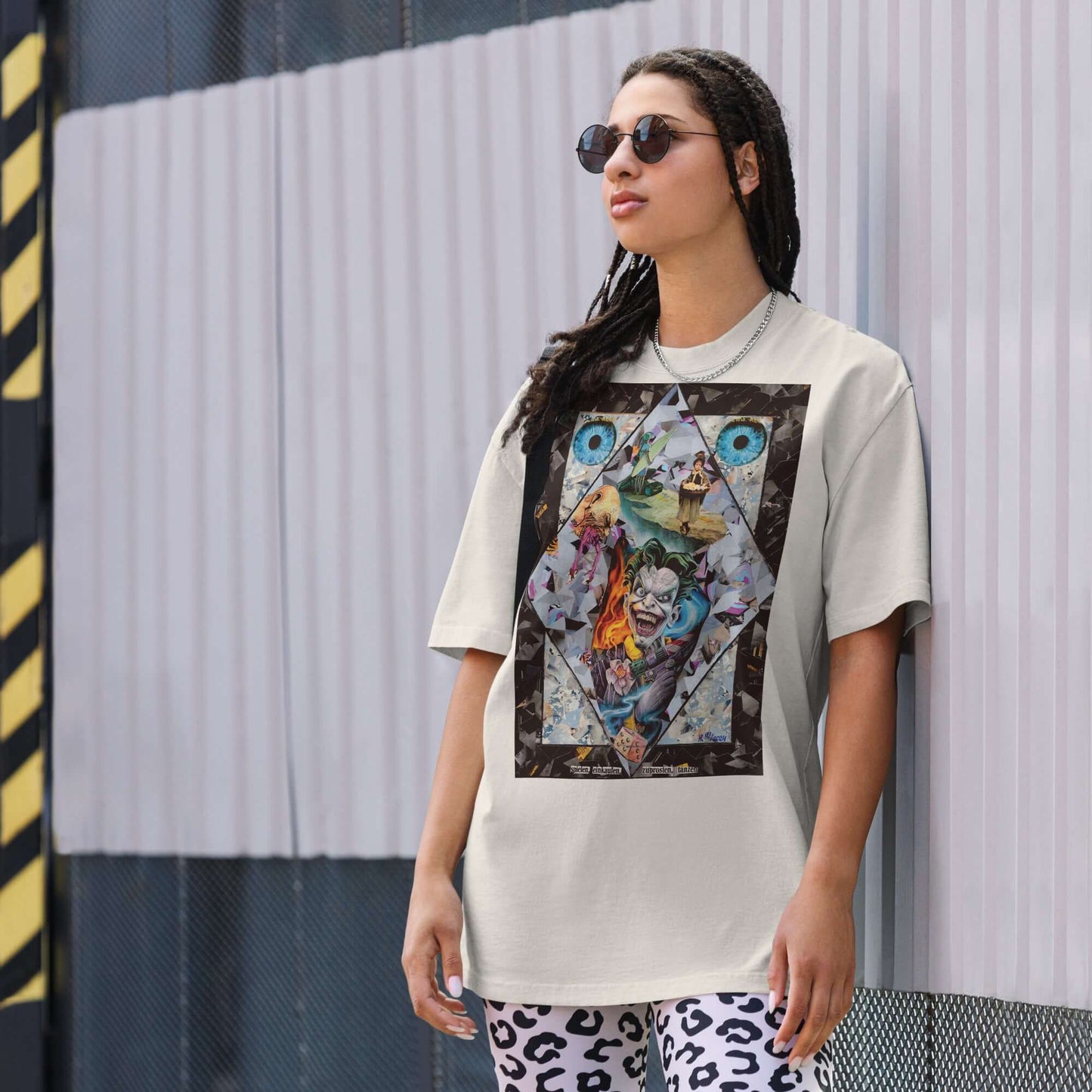 Oversized T-Shirt featuring chaotic urban art, worn by a model in sunglasses against a textured backdrop.